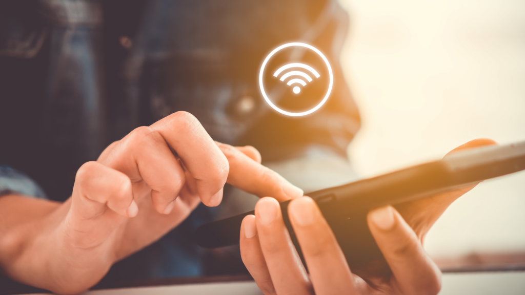 Woman hand using smartphone with wifi icon in cafe shop background.