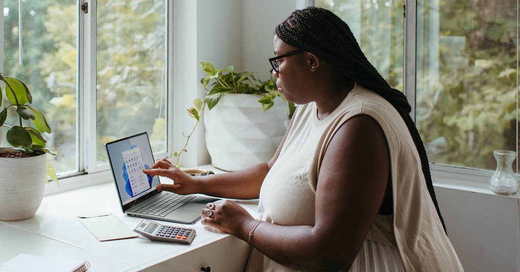 Woman at table with laptop and calculator