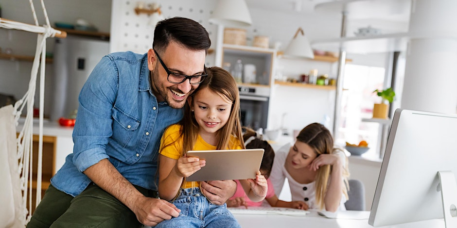 Young family using ipad and computer at home