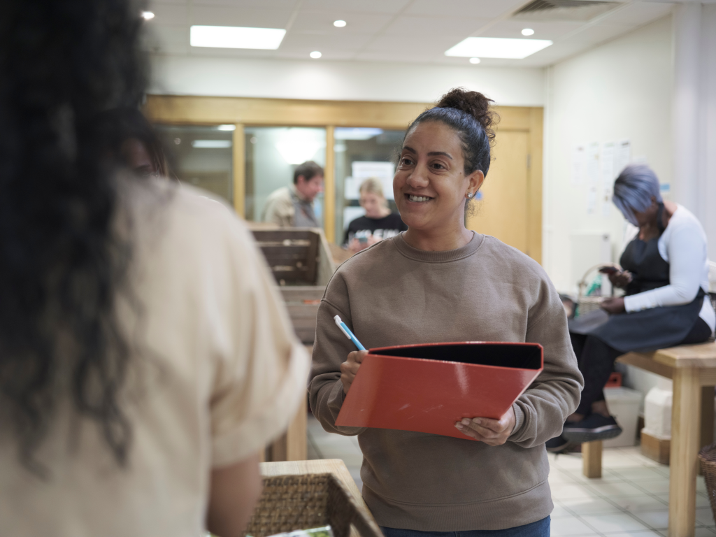 Young woman in a community centre with a clipboard