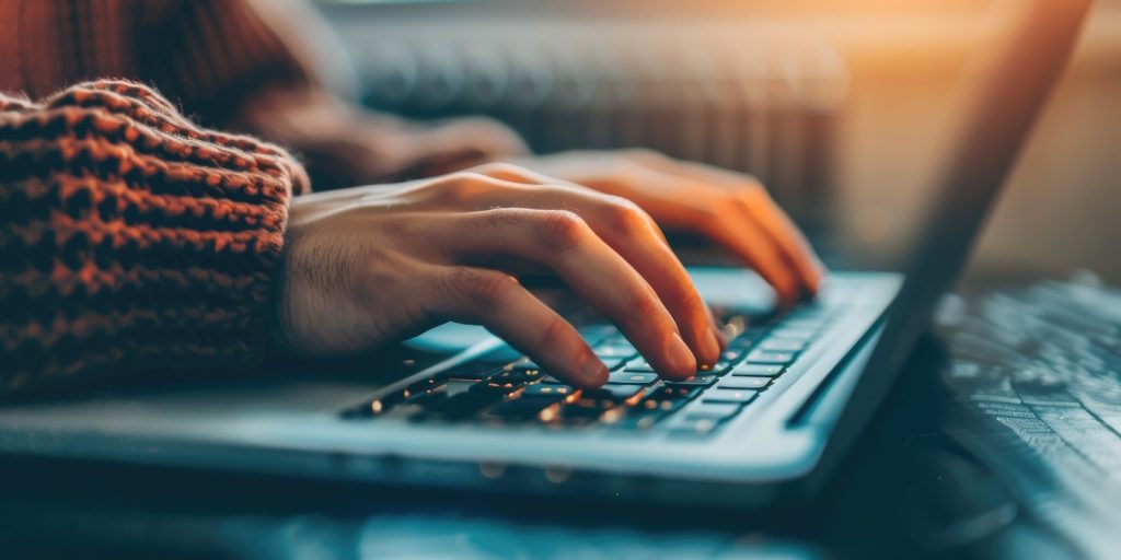 A closeup perspective showing hands typing on a keyboard for various digital activities AIG62